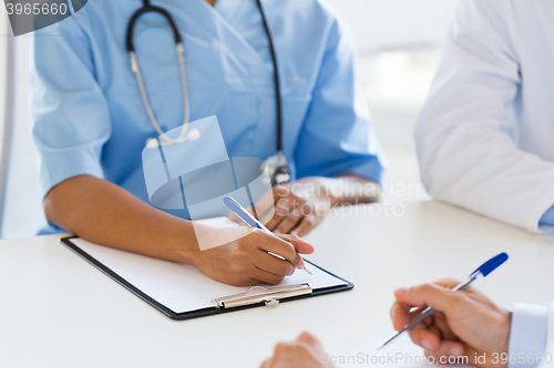 Image of group of doctor with clipboard writing at hospital