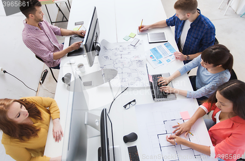 Image of creative team with computers, blueprint at office