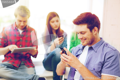 Image of student looking into smartphone at school