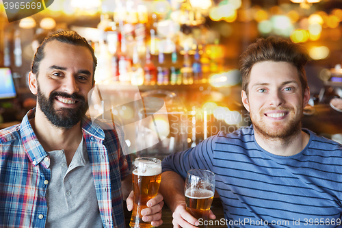 Image of happy male friends drinking beer at bar or pub