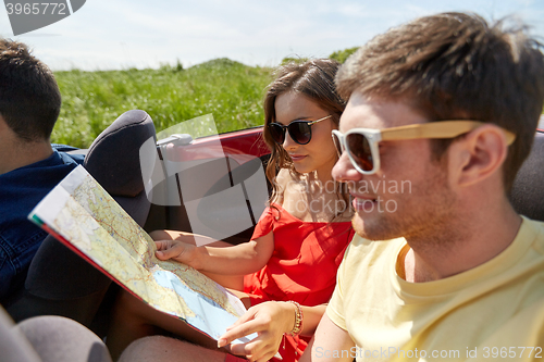 Image of happy friends driving in cabriolet car