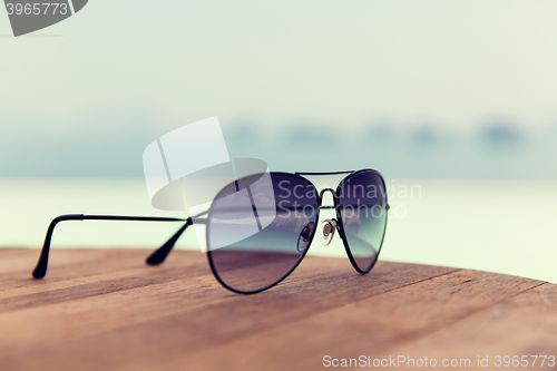 Image of shades or sunglasses on table at beach