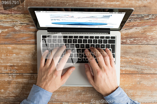 Image of close up of male hands with laptop typing