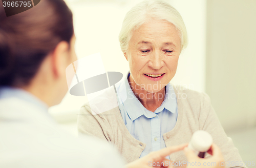 Image of doctor with medicine and senior woman at hospital