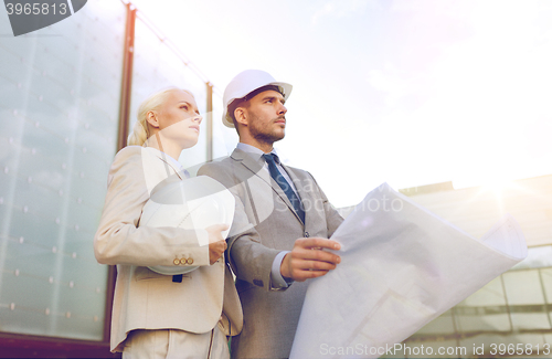 Image of businessmen with blueprint and helmets