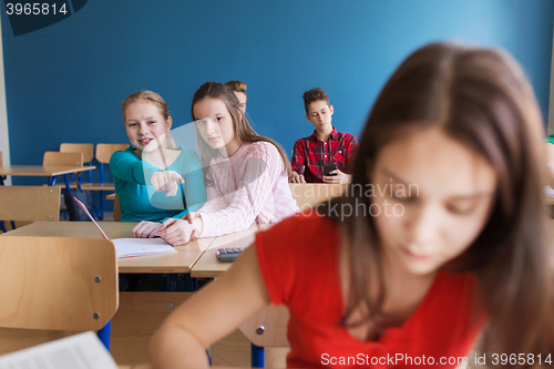 Image of students gossiping behind classmate back at school