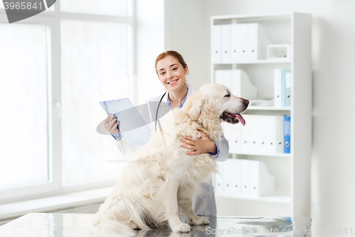 Image of happy doctor with retriever dog at vet clinic
