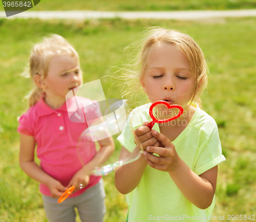 Image of group of kids blowing soap bubbles outdoors