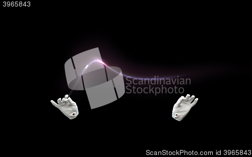 Image of magician hands with magic wand showing trick