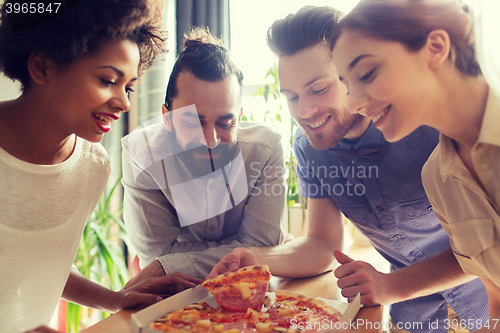 Image of happy business team eating pizza in office