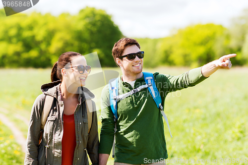 Image of happy couple with backpacks hiking outdoors