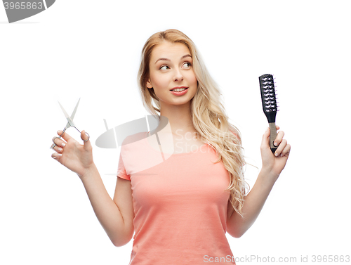 Image of young woman with scissors and hairbrush