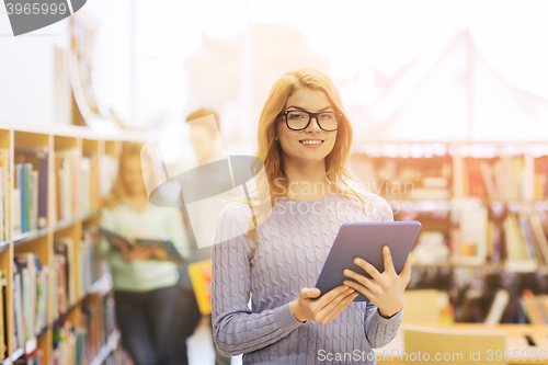 Image of happy student girl with tablet pc in library