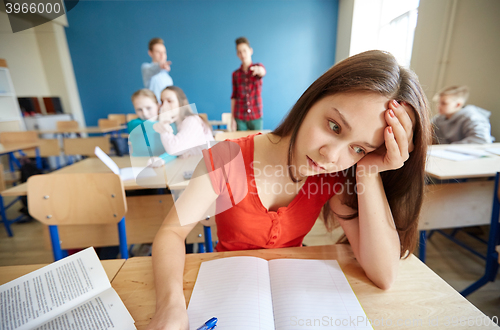 Image of students gossiping behind classmate back at school