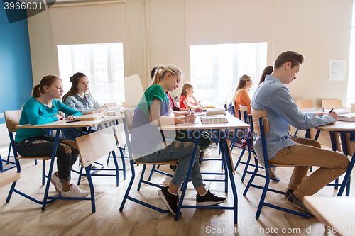 Image of group of students with books writing school test