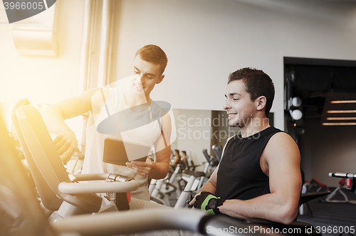 Image of men exercising on gym machine