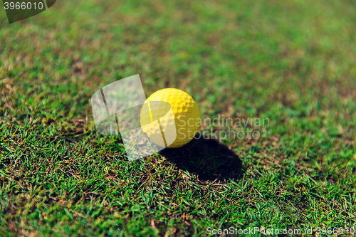 Image of close up of yellow golf ball on green grass