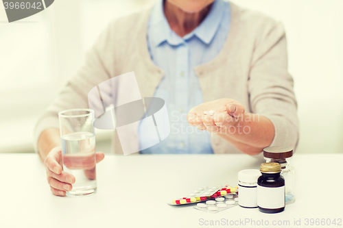 Image of close up of senior woman with water and pills