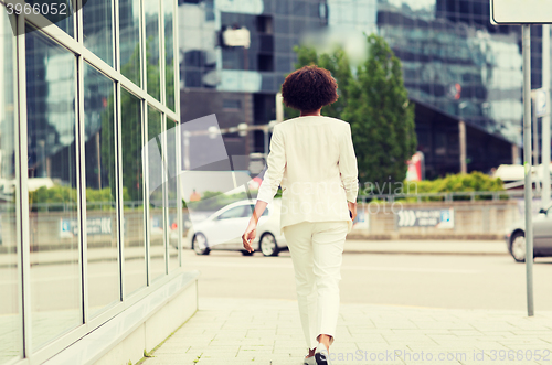 Image of african american businesswoman walking in city