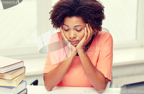 Image of bored african american woman doing homework home