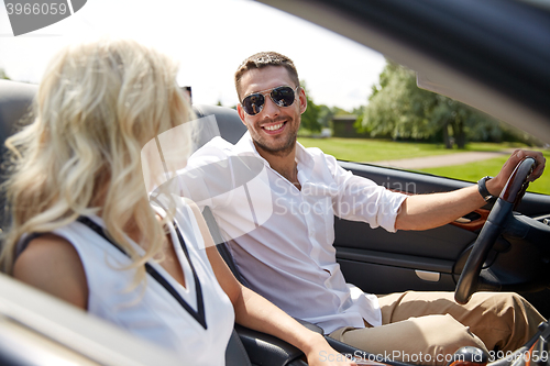 Image of happy man and woman driving in cabriolet car