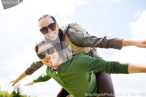 Image of happy couple with backpacks having fun outdoors