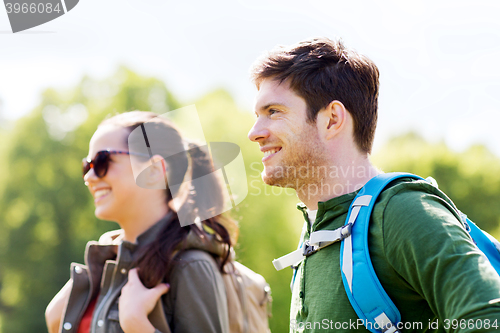 Image of happy couple with backpacks hiking outdoors