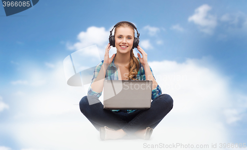 Image of woman with laptop computer and headphones