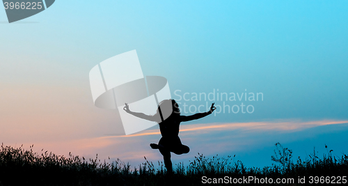 Image of The silhouette of young woman is practicing yoga