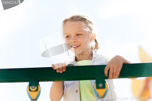 Image of happy little girl climbing on children playground