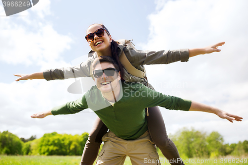 Image of happy couple with backpacks having fun outdoors