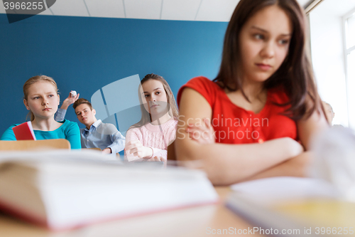Image of students gossiping behind classmate back at school