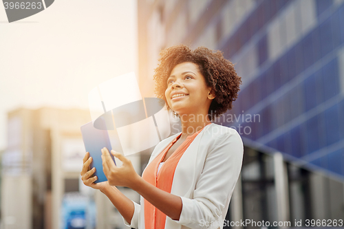 Image of happy african businesswoman with tablet pc in city