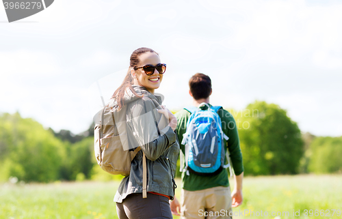 Image of happy couple with backpacks hiking outdoors