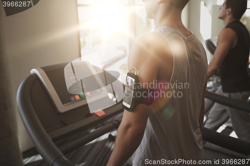 Image of smiling men exercising on treadmill in gym