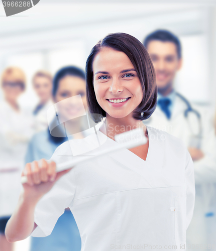 Image of dentist with toothbrush in hospital