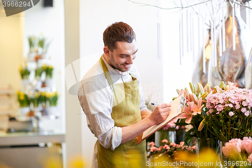 Image of florist man with clipboard at flower shop