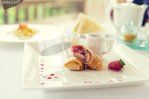 Image of close up of pancakes and honey or jam on plate