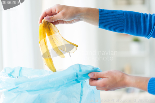 Image of close up of hand putting food waste to rubbish bag