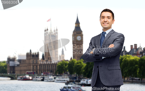 Image of happy smiling businessman in suit over london city