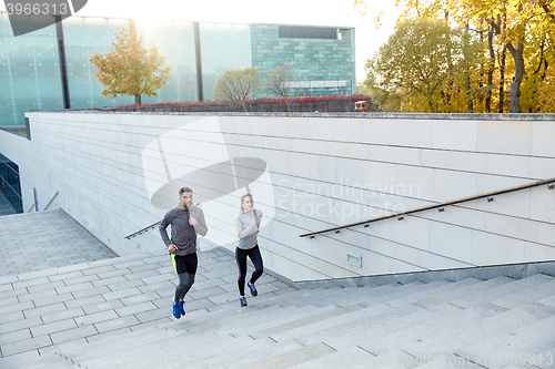 Image of happy couple running upstairs on city stairs