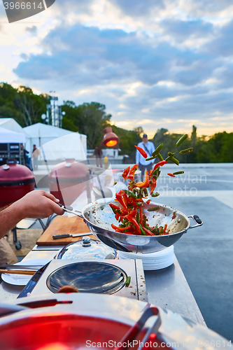 Image of chef tossing vegetables in a wok