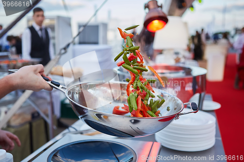 Image of chef tossing vegetables in a wok