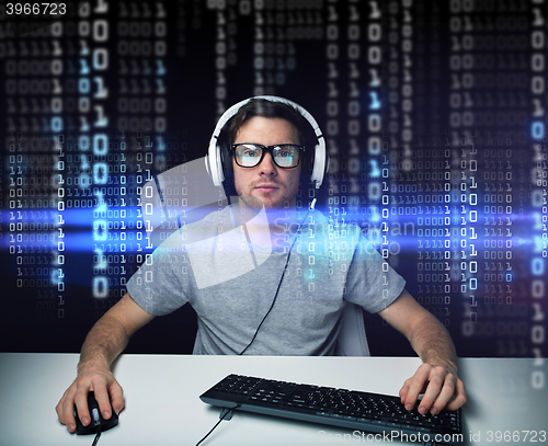 Image of man in headset hacking computer or programming