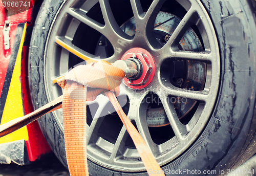 Image of close up of race car wheel with tow rope tied to