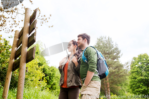 Image of smiling couple with backpacks hiking