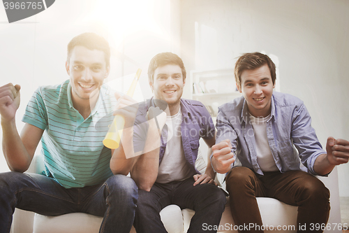 Image of happy male friends with vuvuzela
