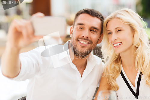 Image of happy couple taking selfie with smatphone outdoors