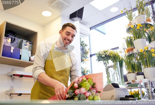 Image of florist wrapping flowers in paper at flower shop