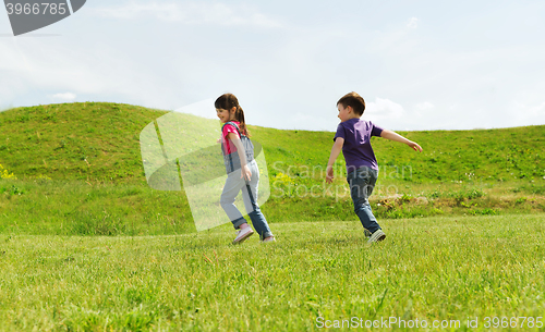 Image of happy little boy and girl running outdoors